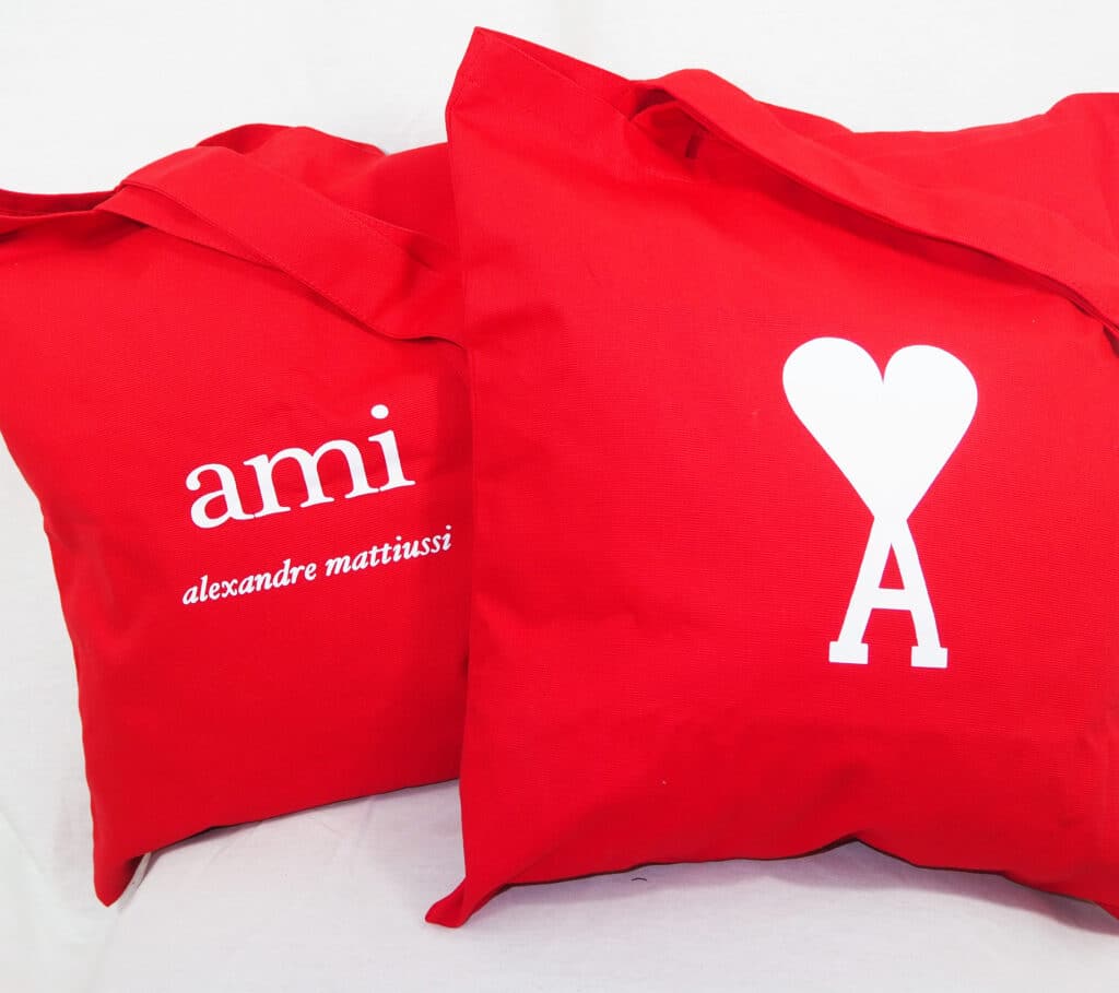 Tote-bags rouges avec double anses : AMI Paris (Alexandre Mattiussi) et logo rouge cœur Ami de cœur